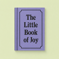 Lilac A7 fabric hardback notebook with black The Little Book of Joy lettering on a pale yellow background.