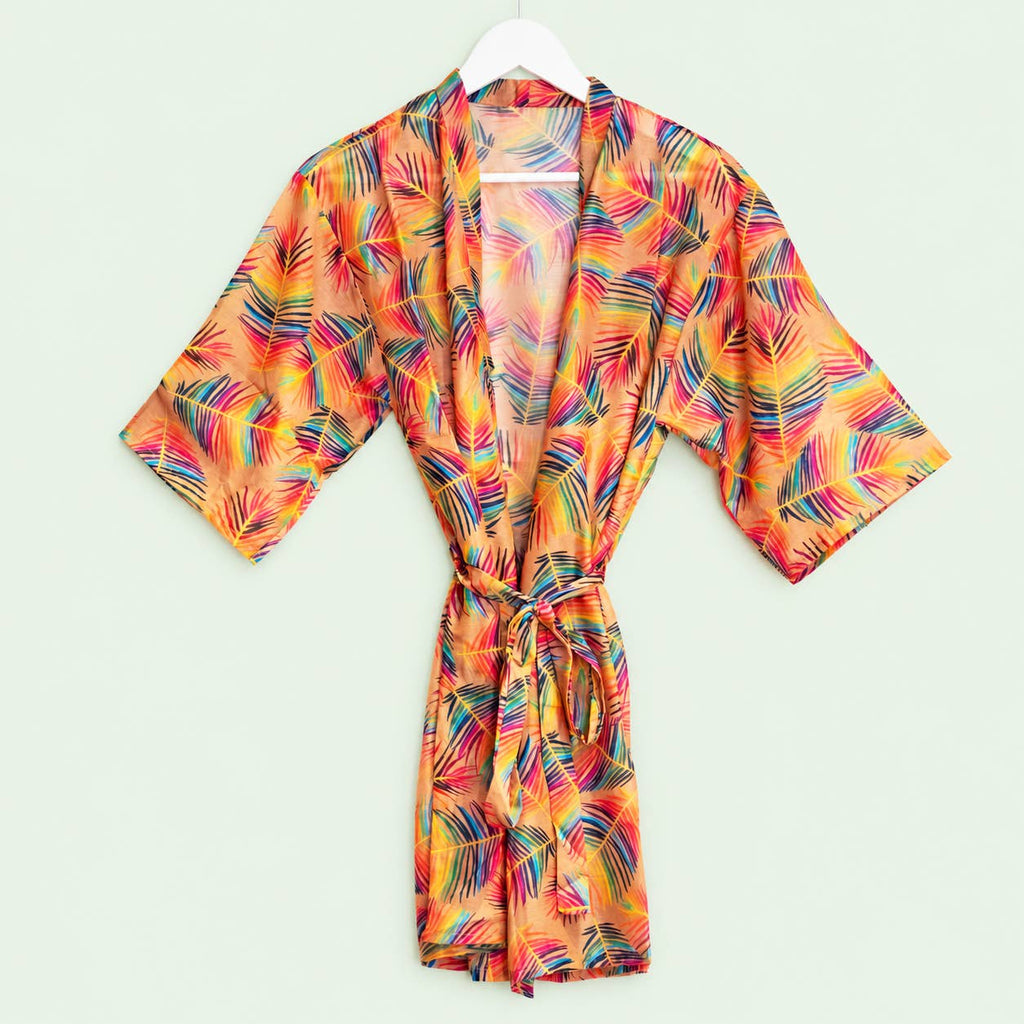Vibrant peach kimono robe with multicoloured tropical leaves, wide sleeves and a matching waist tie displayed on a hanger.