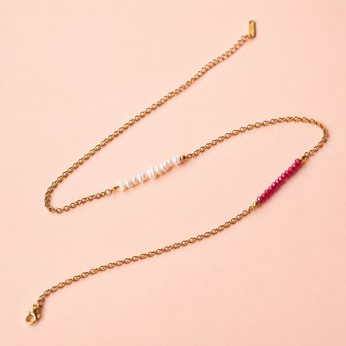 Close up of strawberries and cream necklace showing white pearls, pink beads, gold tone chain and adjustable fastening.