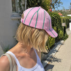 Colourful pink and green striped baseball cap worn outdoors, ready for sunshine, holidays and happy adventures.