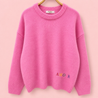 Front of pink knitted jumper with small multicoloured AMOUR embroidery near the hem.
