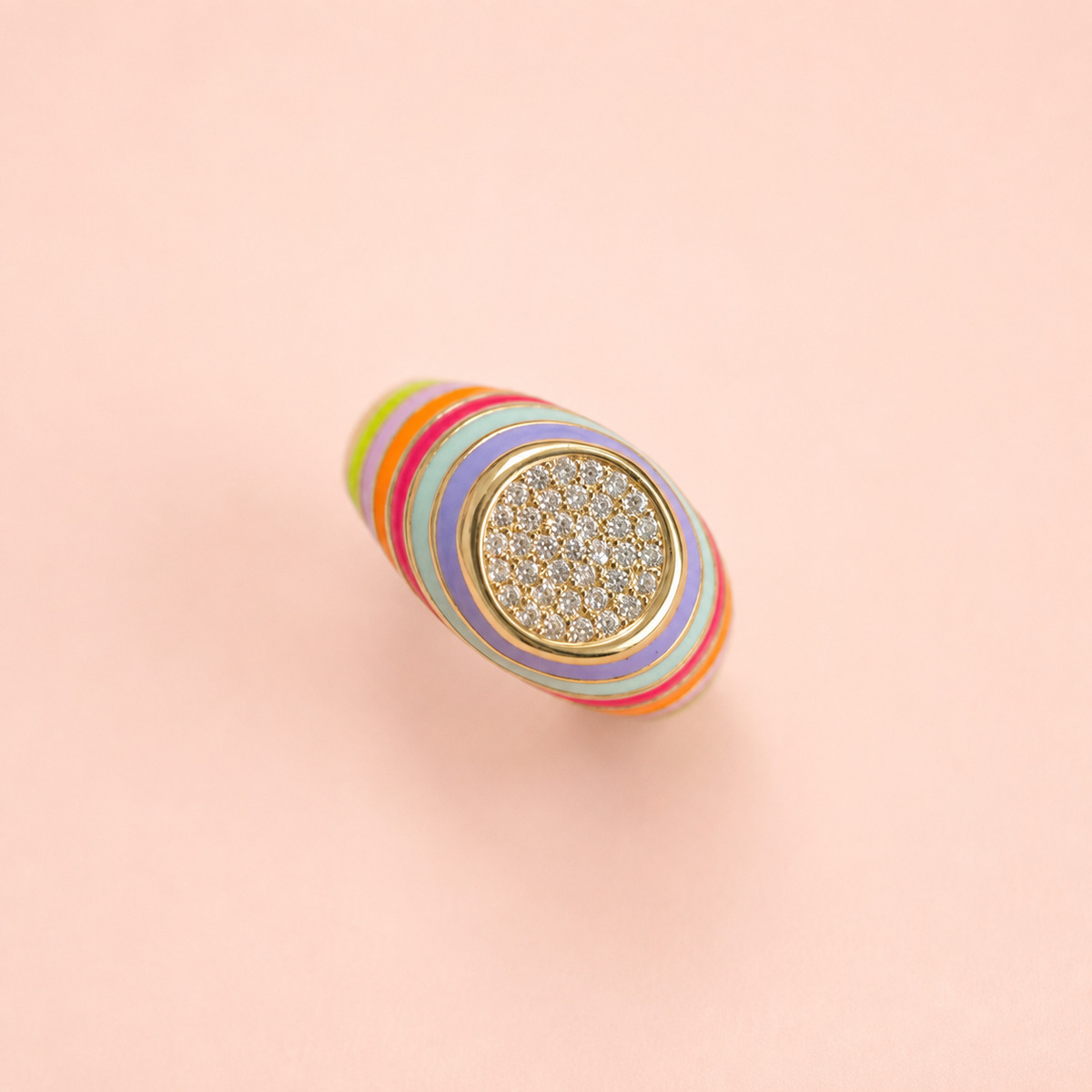 Front view of multicolour striped enamel signet ring with crystal set centre on a pale pink background.