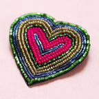 Heart shaped brooch with layered pink, green, navy and gold seed bead detailing.