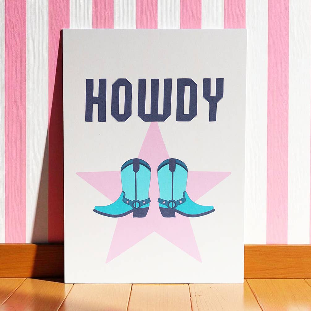 Colourful Howdy A5 art print featuring turquoise cowboy boots over a pink star with bold navy lettering.