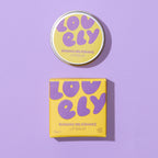 Banana Milkshake Lip Balm 10g tin and yellow box displayed against a lilac background.