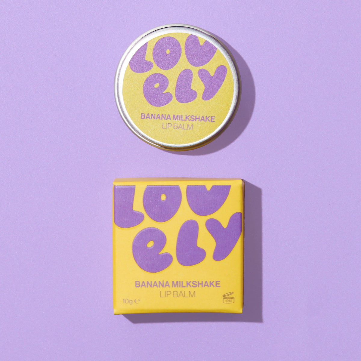 Banana Milkshake Lip Balm 10g tin and yellow box displayed against a lilac background.