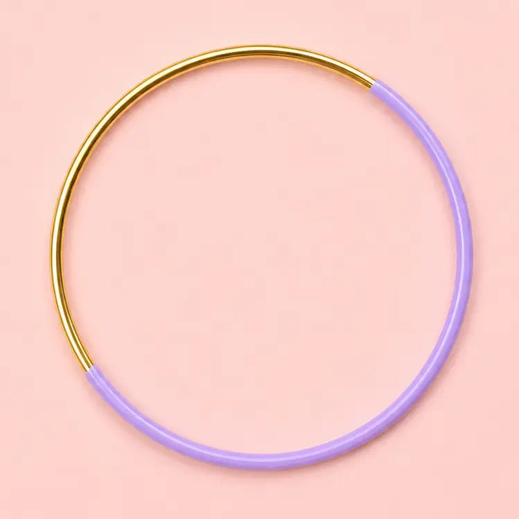 Lilac dip enamel stacking bangle with a polished gold tone finish on a pale pink background.