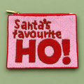 A rectangular beaded zip pouch with a gold zipper, featuring the text 'Santa's favourite HO!' in red and pink beads, set against a solid sage green background.