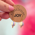 Limited edition retro striped acrylic drop earrings with yellow centres and colourful stripes on Pocketful of Joy card.